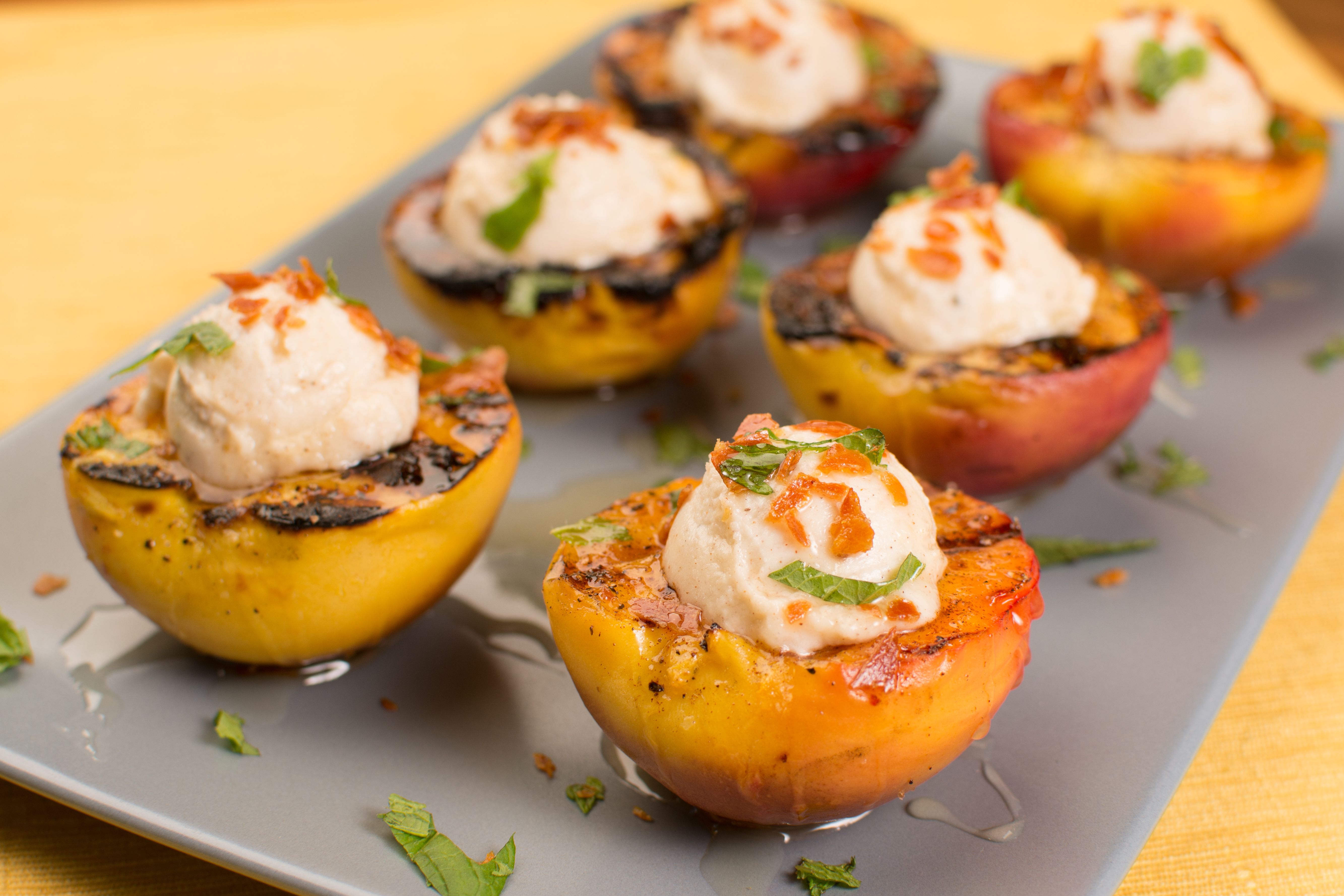 Grilled peaches with grill marks in a glass of white wine