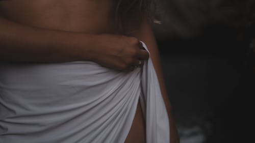 Free Woman in White Dress Holding Her Stomach Stock Photo