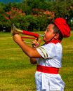 Boy in White Shirt and Red Shorts Playing Trumpet