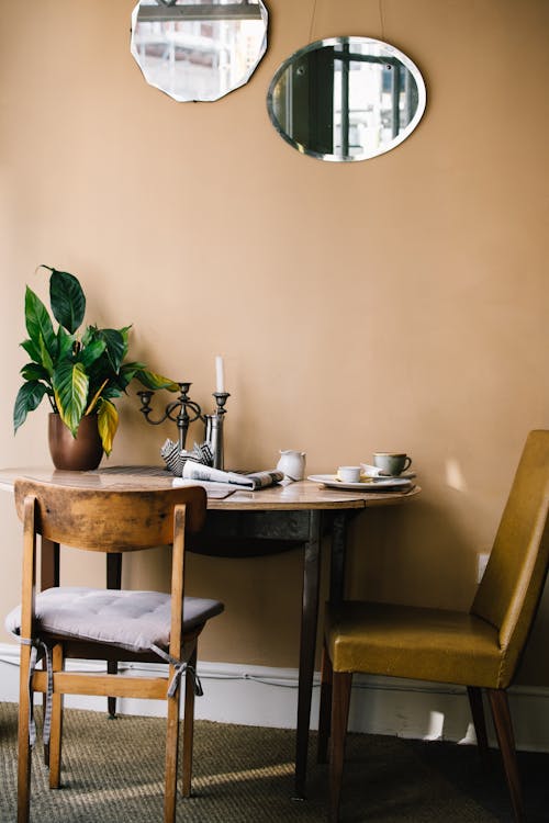 Round Brown Wooden Table With Two Brown Chairs