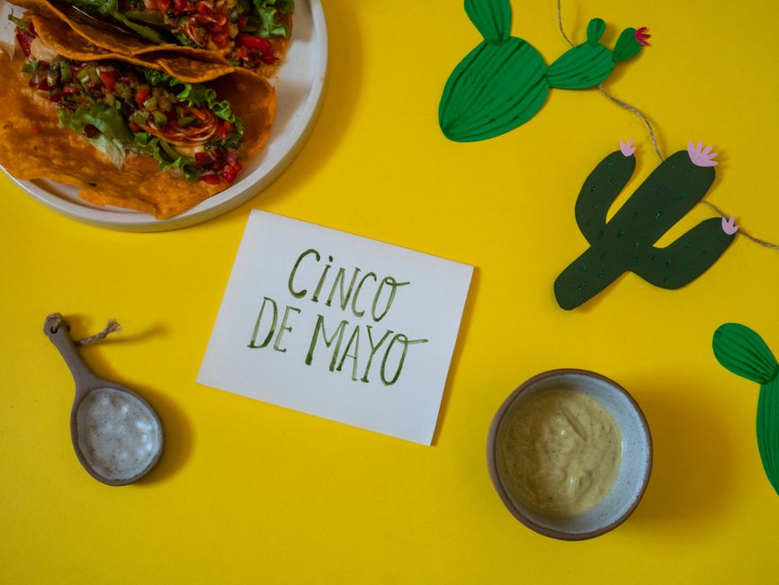 Photo by Polina ⠀ Colorful Cinco de Mayo celebration setup with tacos, vibrant decor, and a festive vibe.