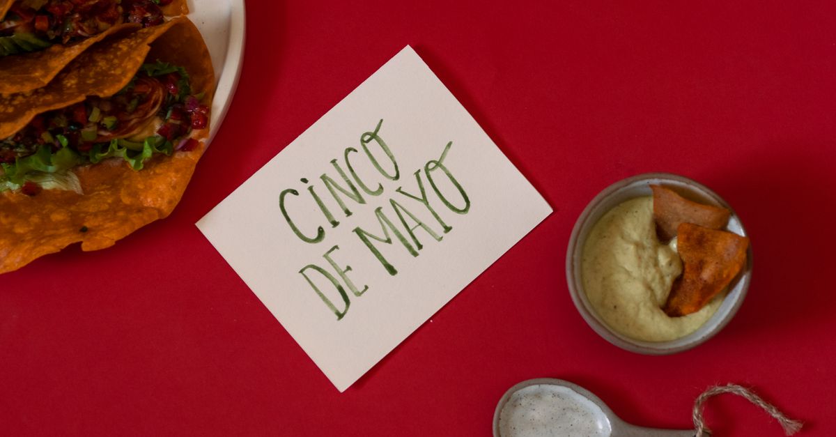 close up of birria taco being dipped into rich red consommé