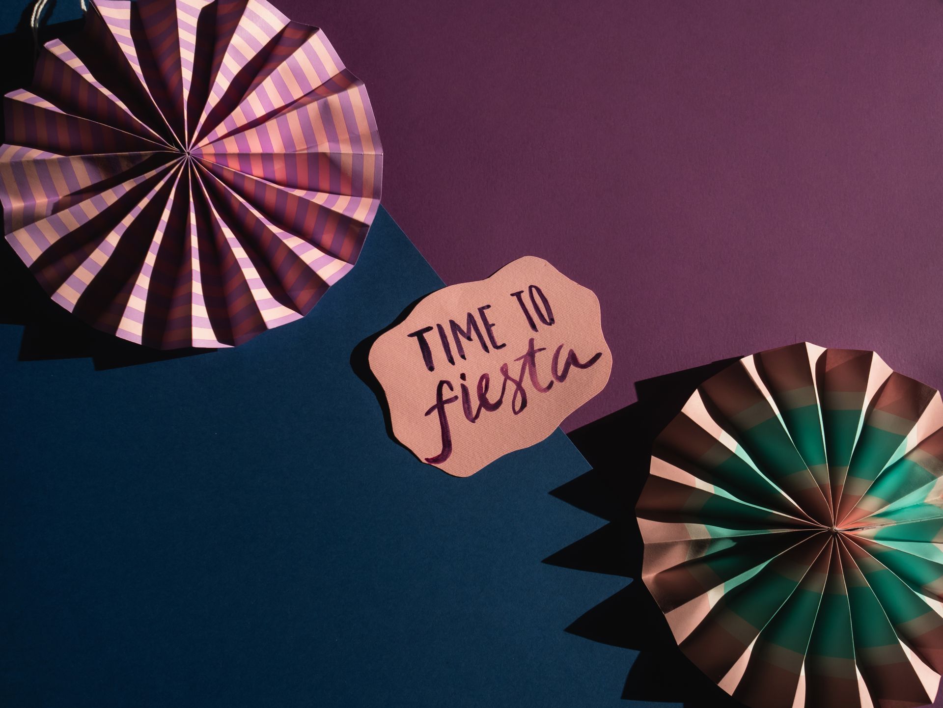 Colorful paper decorations laid out for a fiesta celebration with a 'Time to Fiesta' sign.