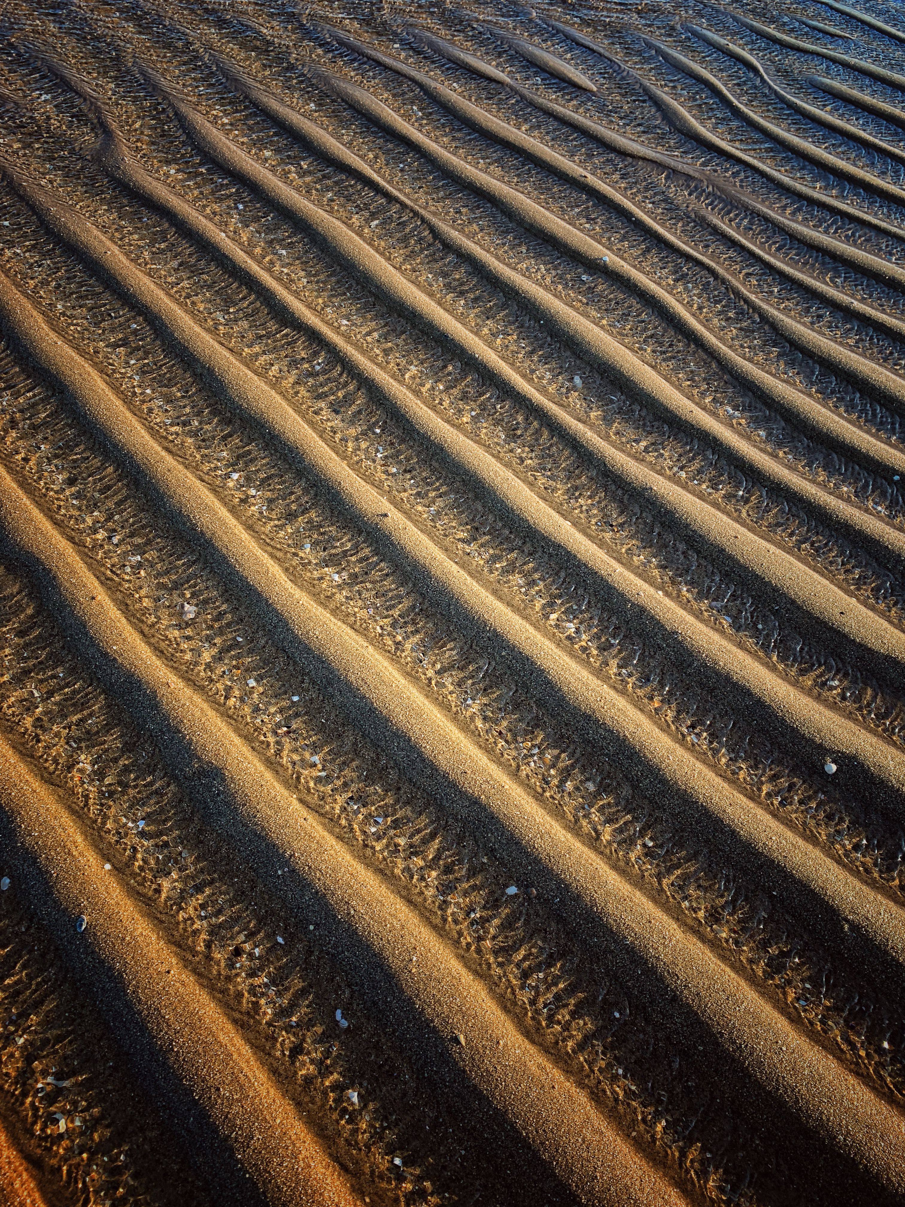 Close-up of textured sand patterns on Punta del Moral beach, Andalusia.