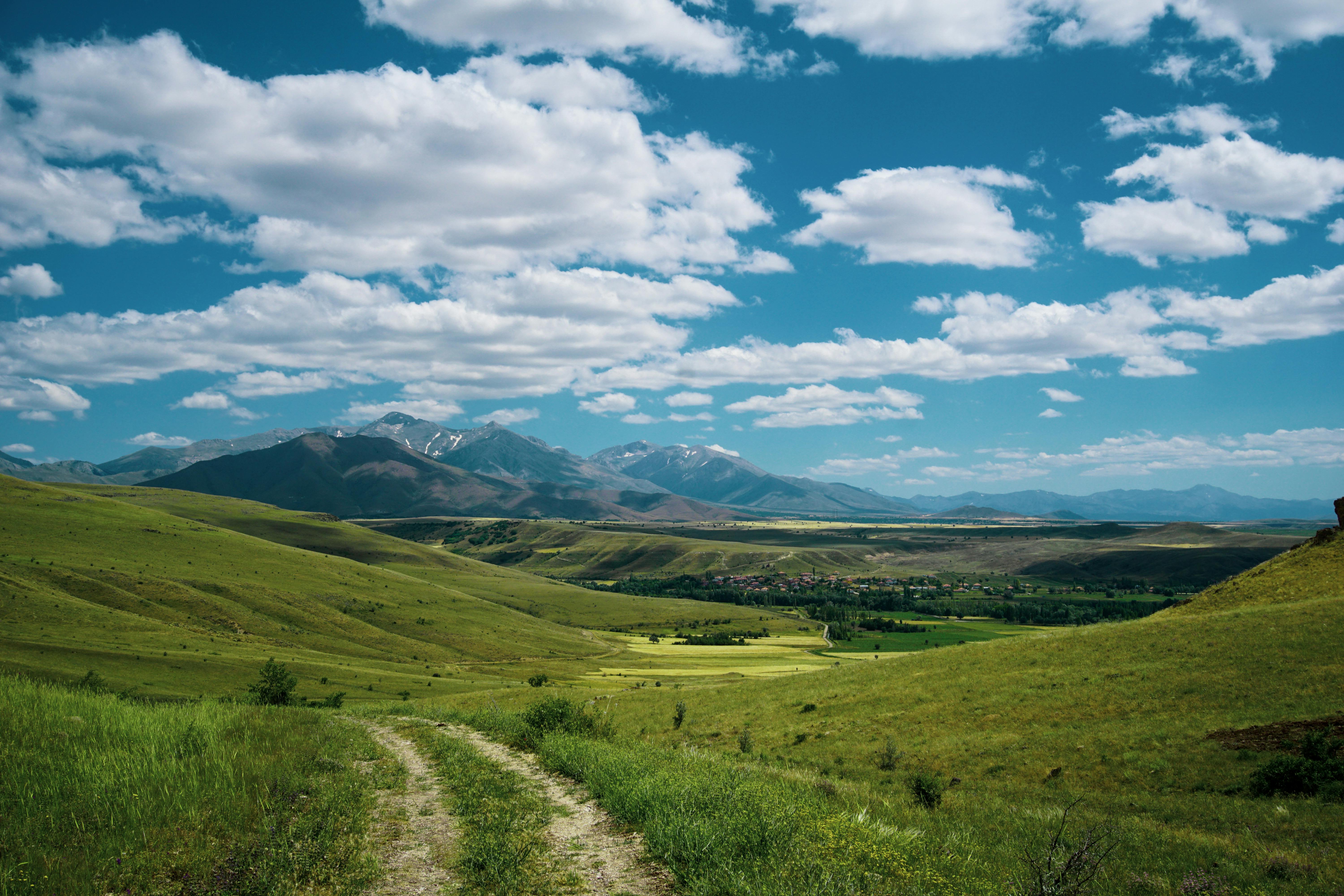 Scenic View of a Grass Field near the Mountains · Free Stock Photo
