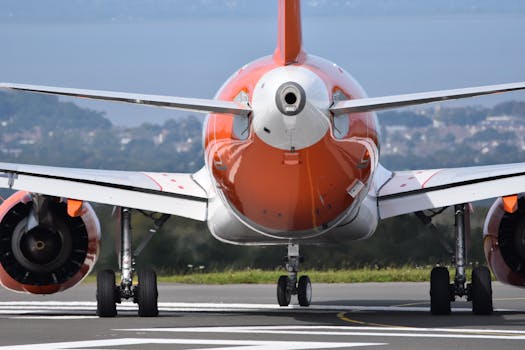 A close-up back view of an airplane on a runway, ready for takeoff on a clear day.