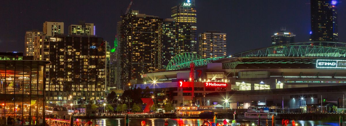 Illuminated Melbourne waterfront cityscape at night showcasing vibrant urban life and architecture.