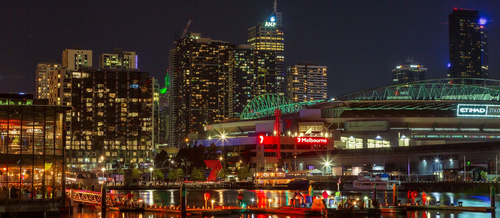 Illuminated Melbourne waterfront cityscape at night showcasing vibrant urban life and architecture. — flights from Darwin to Melbourne