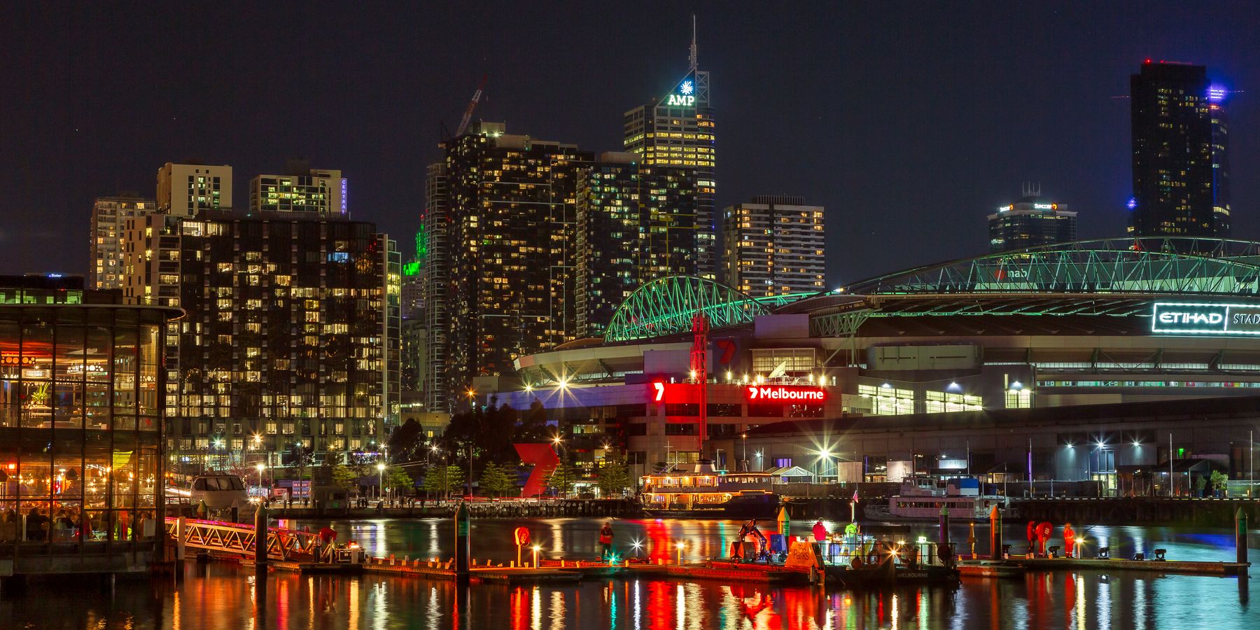Illuminated Melbourne waterfront cityscape at night showcasing vibrant urban life and architecture.
