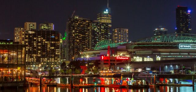 Illuminated Melbourne waterfront cityscape at night showcasing vibrant urban life and architecture.