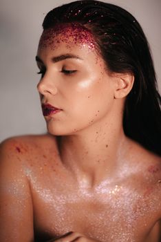 Elegant woman adorned with glitter, showcasing a stylish and fashionable look in a closeup portrait.