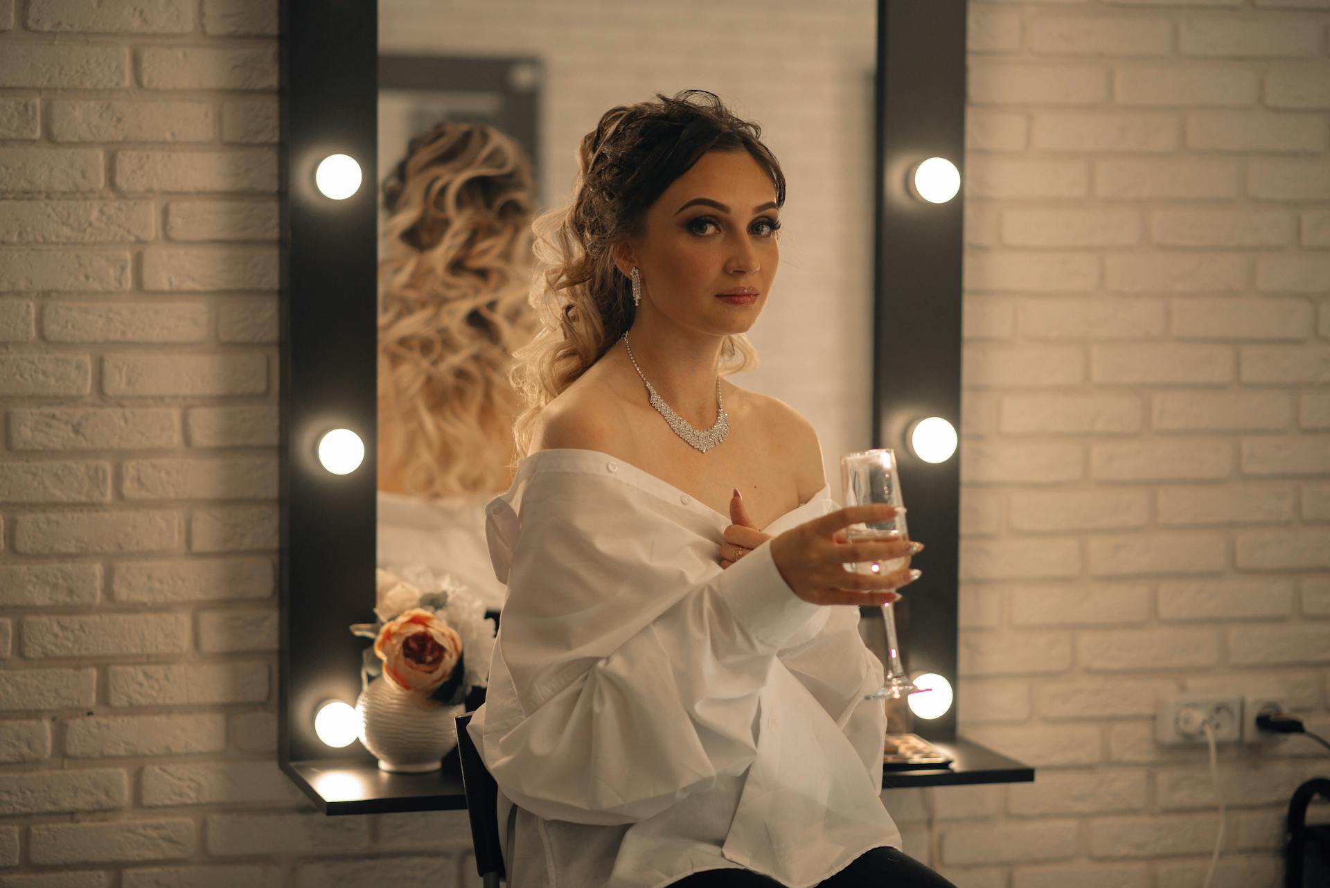 A Woman in White Off Shoulder Top Holding a Champagne Glass