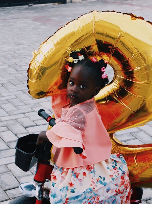 A Girl with Yellow Balloon Riding a Bike