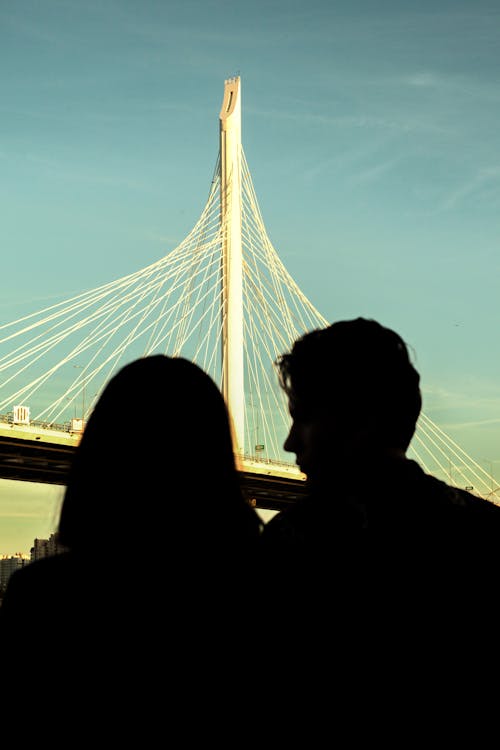 Silhouette of Couple Standing Near the Bridge