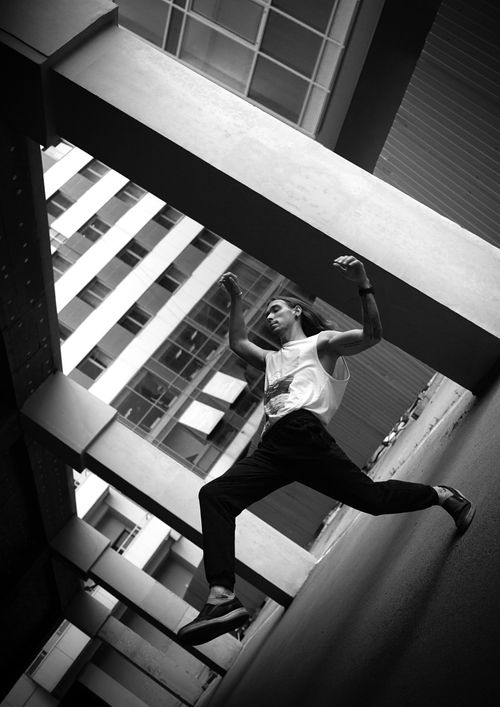 Free Black and white photo of a parkour athlete performing in an urban setting, showcasing energy and movement. Stock Photo