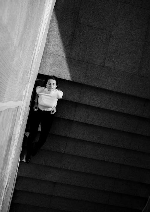 High-Angle Shot of a Woman Sitting on Stairs