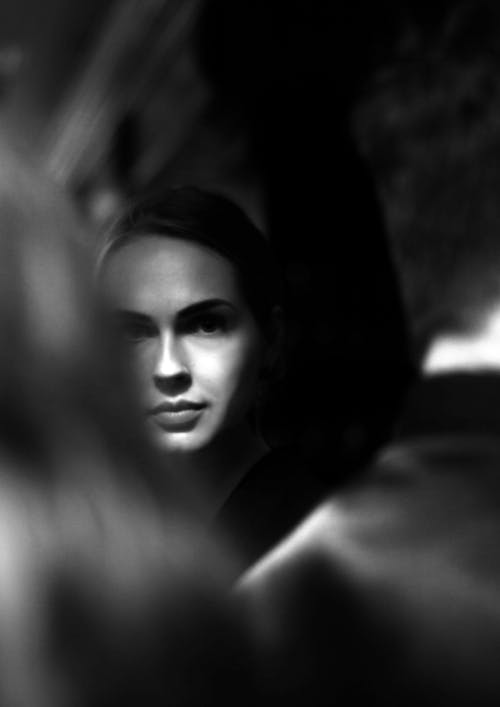 Grayscale Photo of a Woman in the Crowd