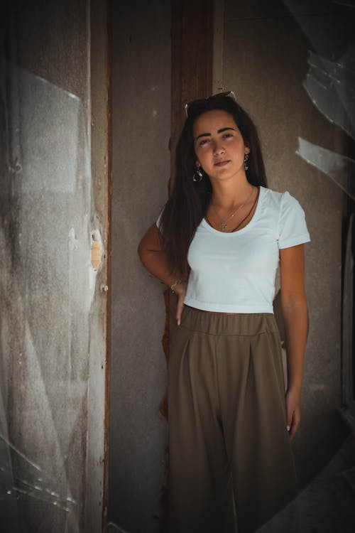 A Woman in White Scoop Neck T-shirt and Brown Pants