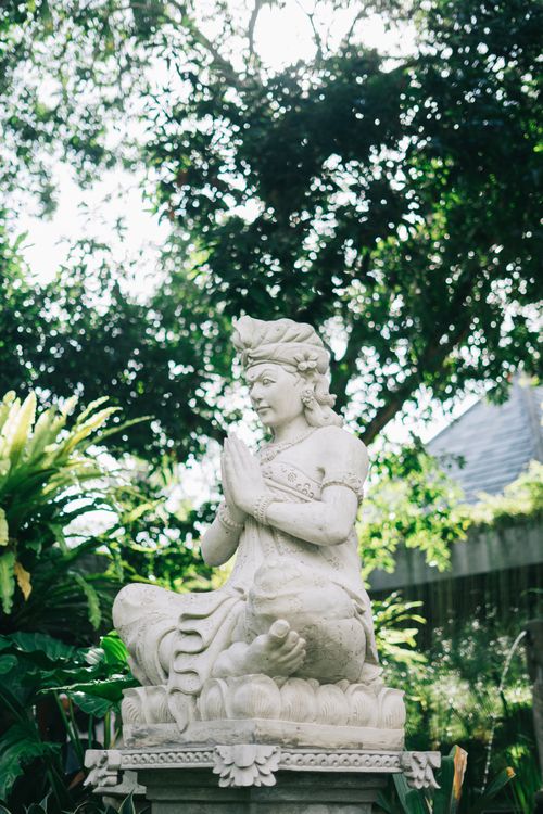 Free A tranquil stone statue in a green garden, symbolizing peace and spirituality. Stock Photo