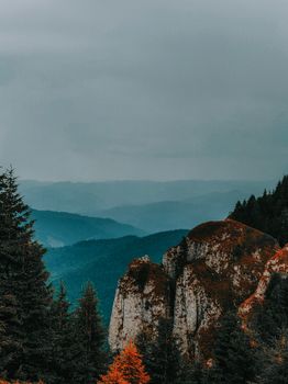 Majestic mountain landscape with cloudy sky and pine trees, perfect for nature themes.