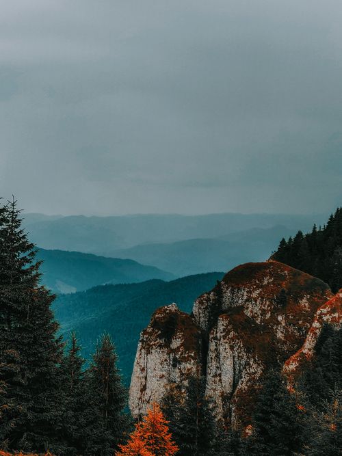 Free Majestic mountain landscape with cloudy sky and pine trees, perfect for nature themes. Stock Photo