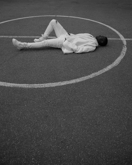 Man in White Pants Lying on the Ground