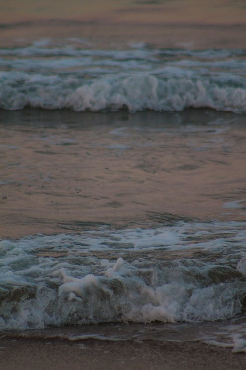 Foamy Waves Rolling to the Seashore at Dusk