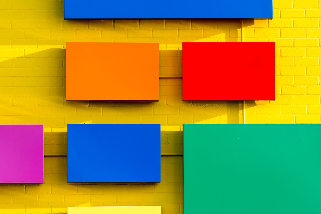 bright geometric rectangles on a yellow brick wall create a vivid and