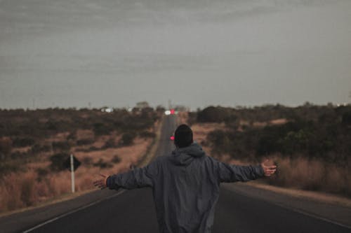 Foto d'estoc gratuïta de amb caputxa, braços oberts, carretera