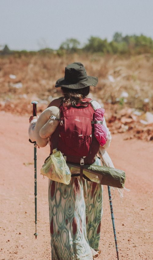 Free A woman with backpack and trekking poles walking on a rural dirt path in Cristalina, Brazil. Stock Photo