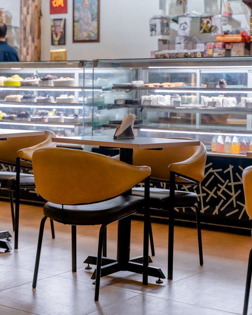 Free Elegant café interior with empty tables and warm lighting, perfect for business or leisure gatherings. Stock Photo