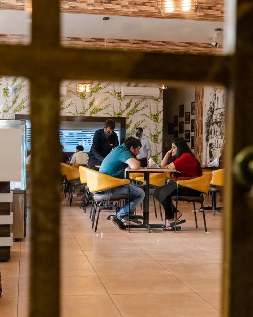 Free A cozy indoor dining scene capturing patrons and staff in a modern restaurant atmosphere. Stock Photo