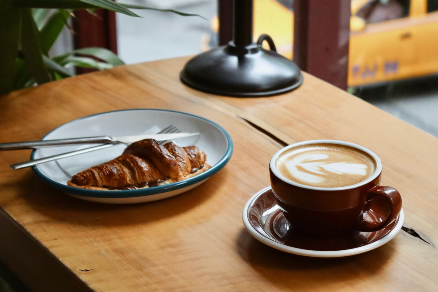 Illustrative photo of coffee and a feta pastry on a café table.
