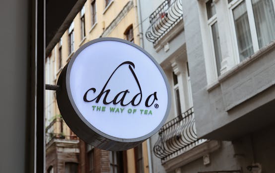 Chado tea shop signage displayed on an elegant historic street with wrought-iron balconies.