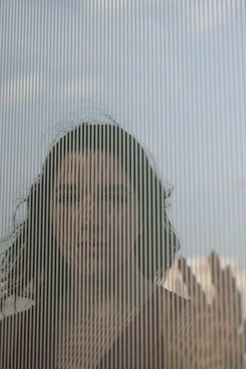 Portrait of a Woman Standing behind a Window
