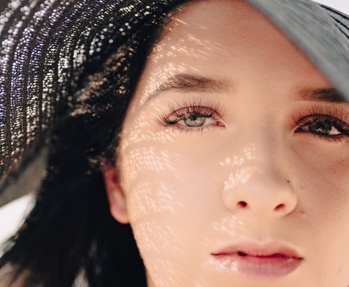 Free Captivating close-up of a woman with intricate shadow patterns on her face, highlighting eyes and lips. Stock Photo