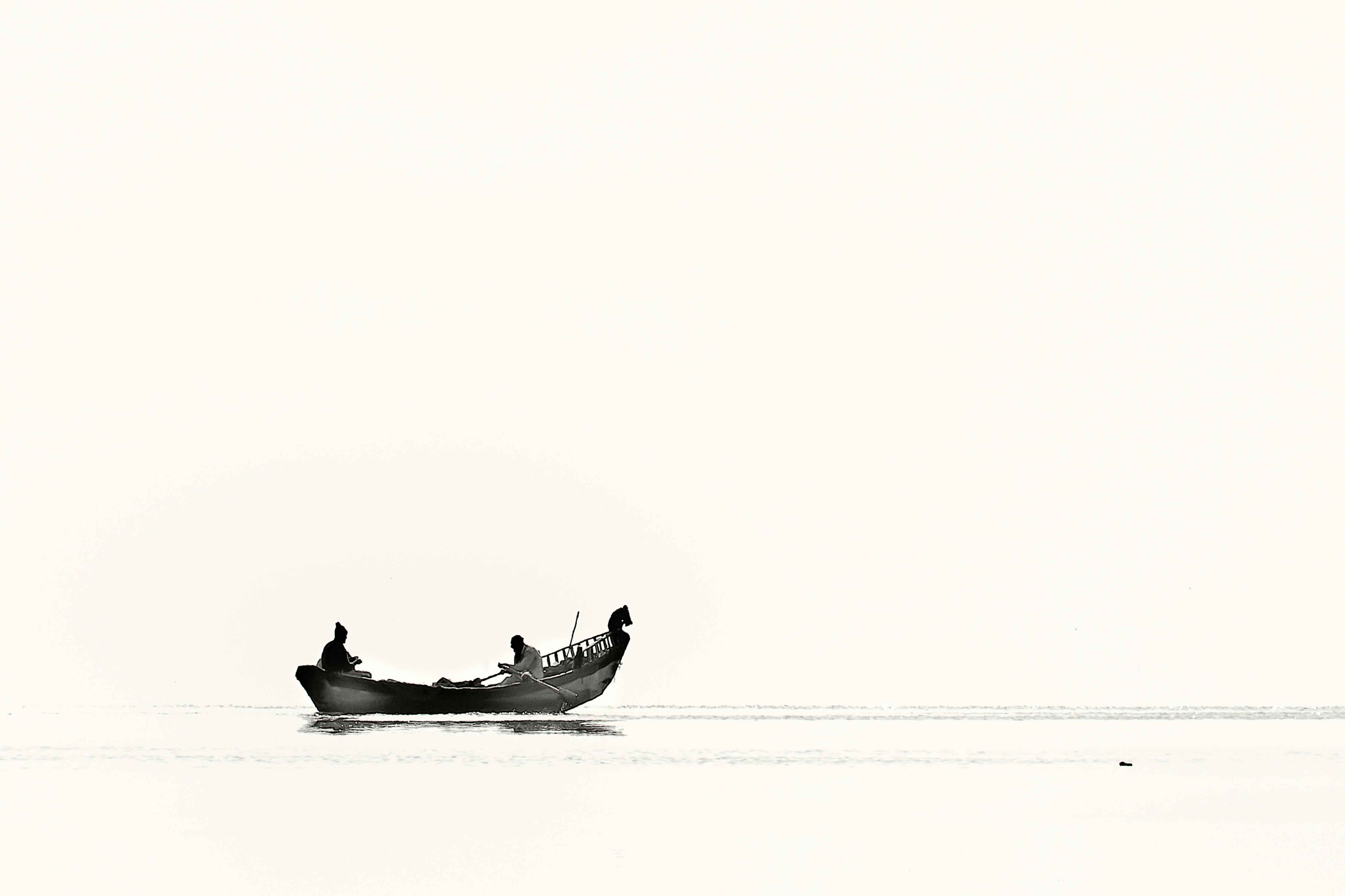 two person riding boat on body of water