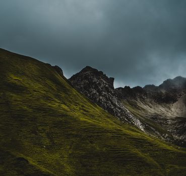 Captivating mountain view with green slopes and dramatic skies, perfect for nature enthusiasts.