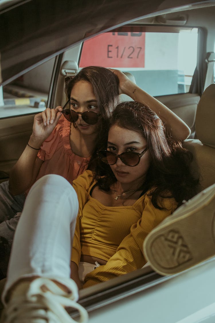 Two Girls In Sunglasses Sitting In The Car