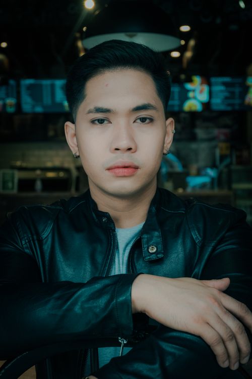 Free Portrait of a young man in a leather jacket indoors with ambient lighting. Stock Photo