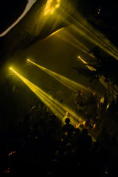Exciting nightlife scene in Türkiye with vibrant lasers illuminating a lively crowd.