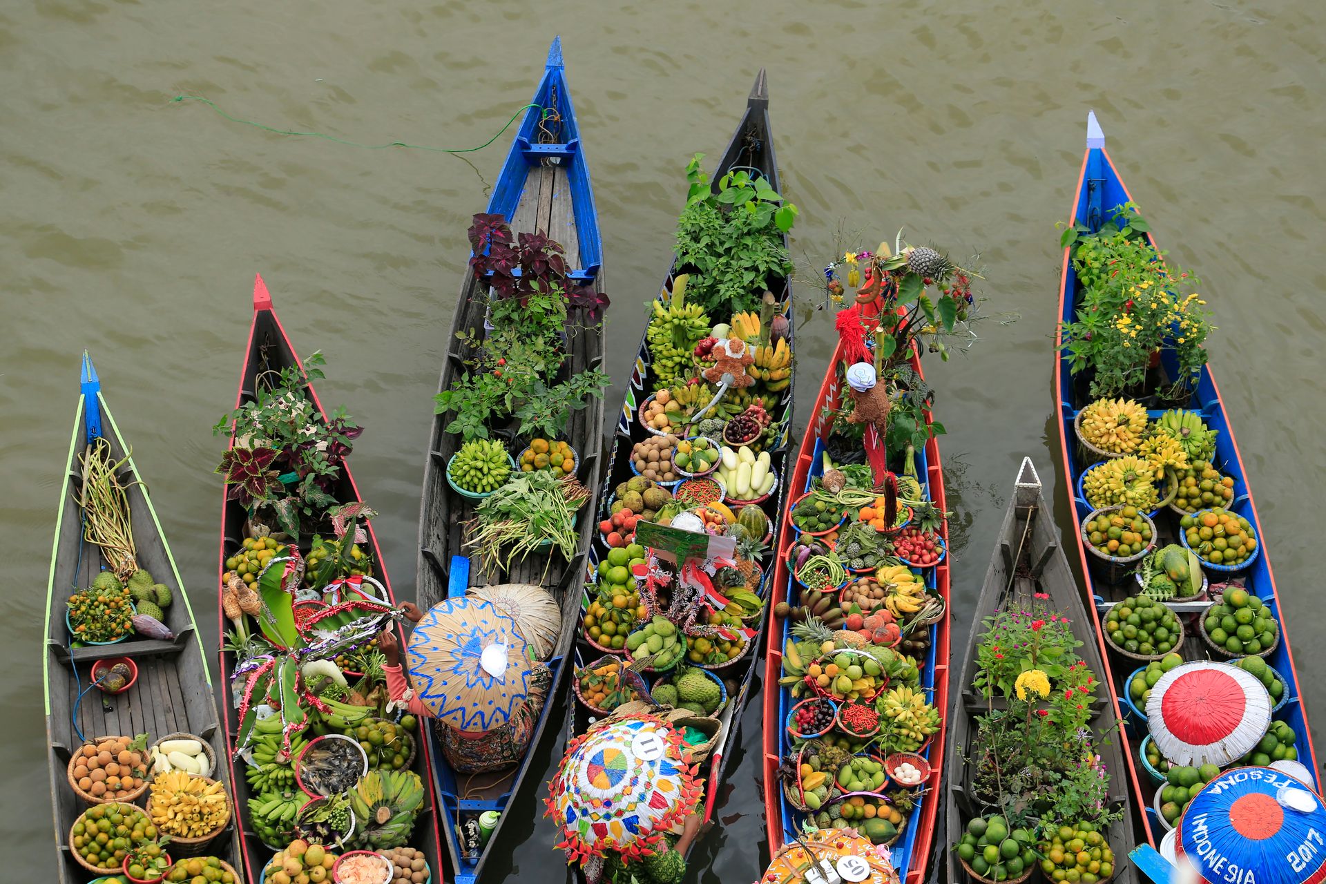 Vibrant scene of boats with fruits and vegetables at Indonesian market