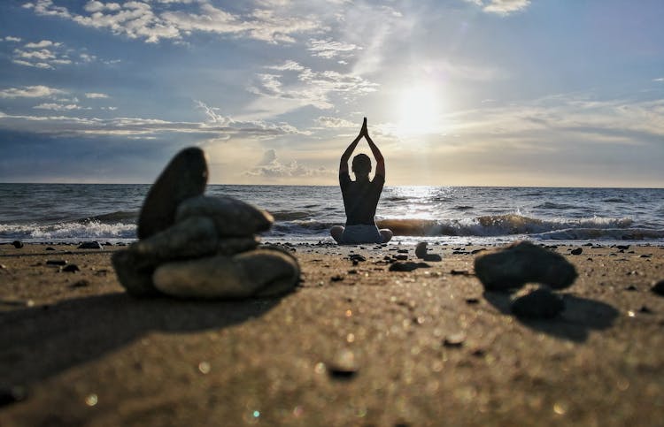 A Woman Doing Yoga On The Shore