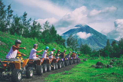 Line Of Men Riding On All Terrain Vehicles Holding Out Hand In A Fist 