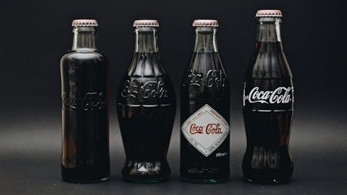 Free 2 Coca Cola Bottles on Black Surface Stock Photo