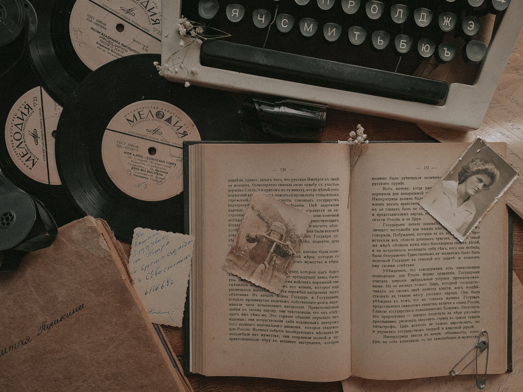 A nostalgic still life featuring a typewriter, vinyl records, and an open book.