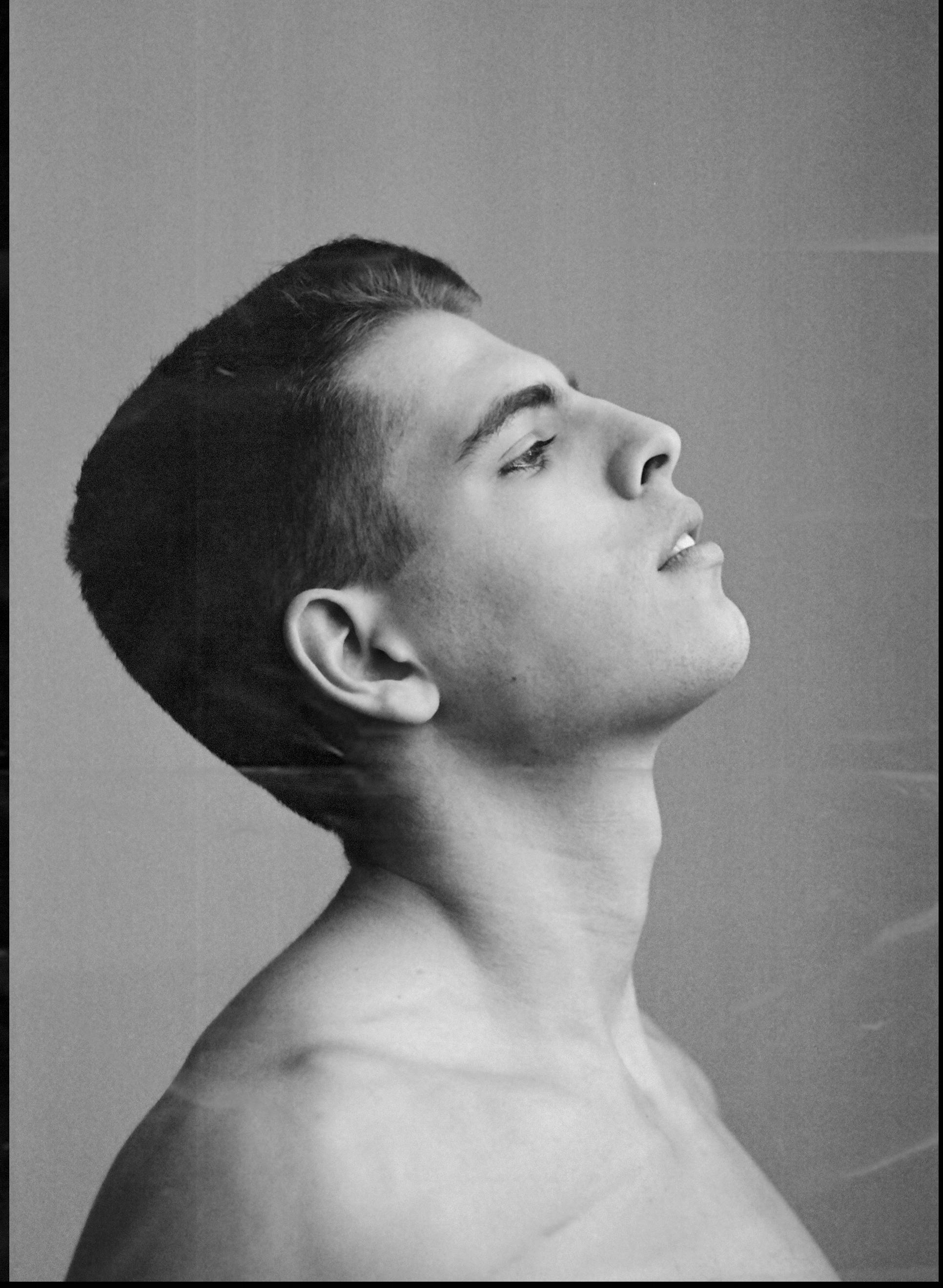 Black and white portrait of a topless man in side view, artistic expression.