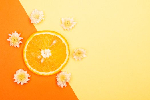 Bright orange slice with flowers on a vibrant orange and yellow background