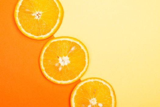 Juicy orange slices on a vivid yellow and orange gradient background.