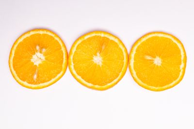 Three orange slices on a white surface — photo by Tamanna Rumee on Pexels